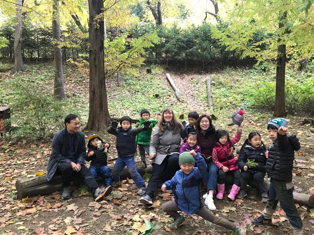 Petra Jäger mit Prof. Dr. Lee inmitten der Kinder vom Waldkindergarten «Traumplatz der Waldkinder»