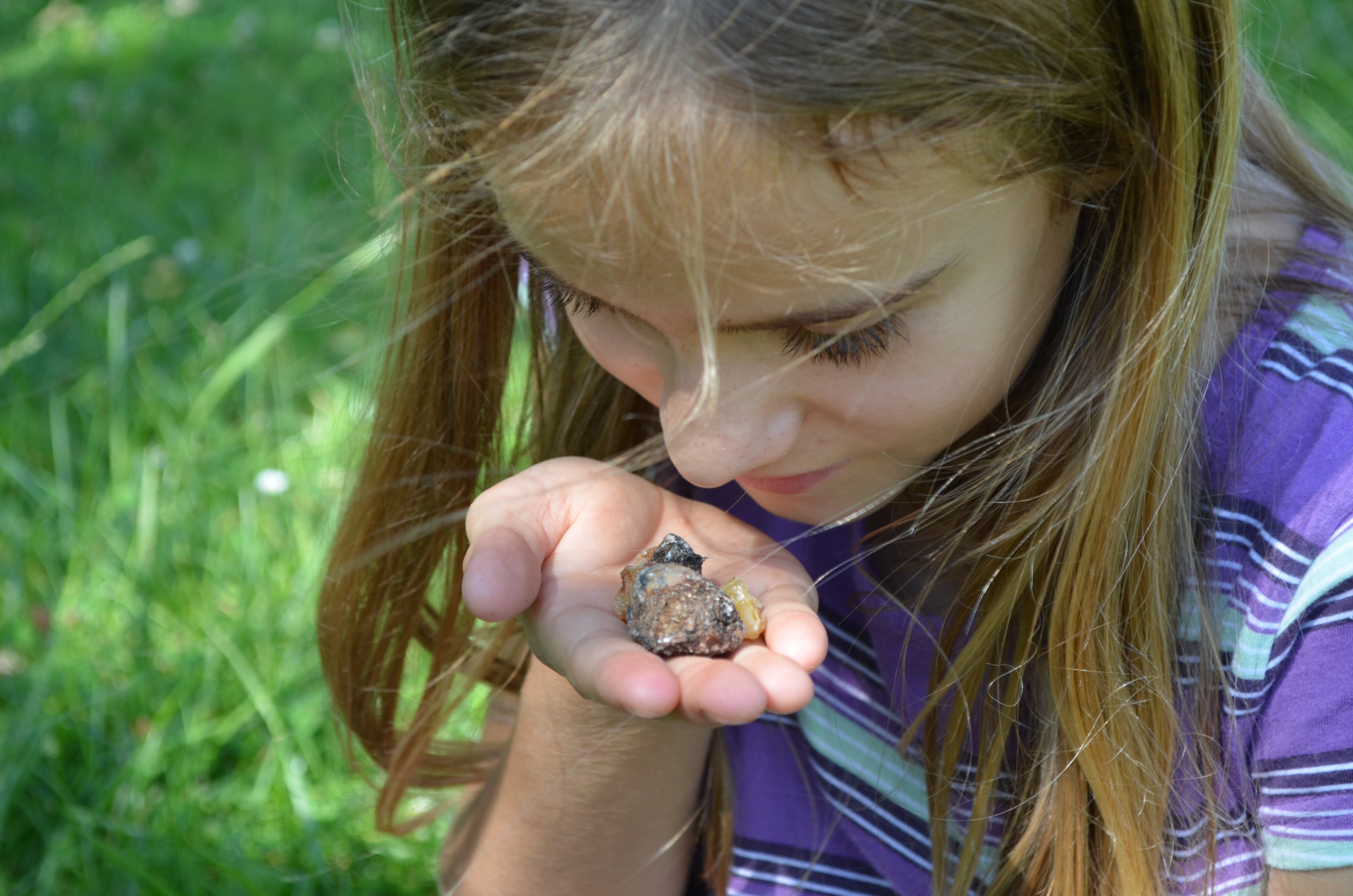 Das Mädchen riecht an einem Fichtenharz. Bei Kindern kann man beobachten, dass das tiefe Urwissen schneller aufbricht, das tief in uns allen verschüttet liegt.