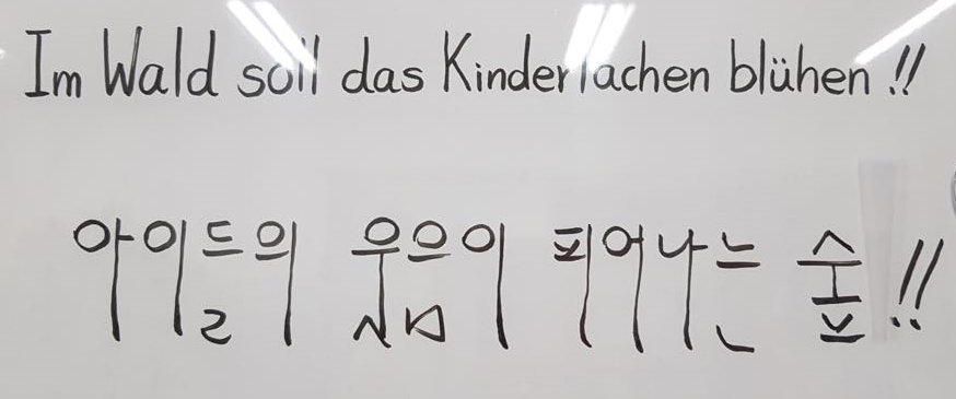 The motto “Children’s laughter shall blossom in the forest”  of the Waldkindergarten written in Korean characters